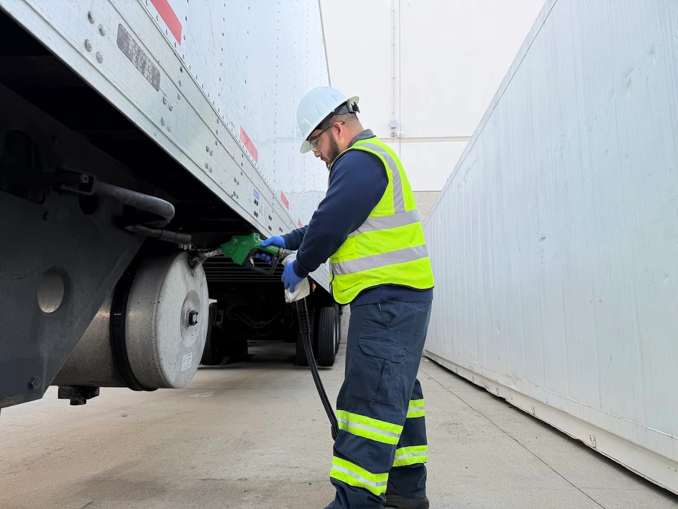 Fuelex team member fueling a refrigerated trailer with a green diesel nozzle